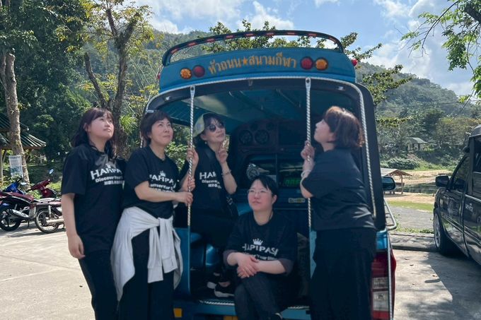 おそろいのTシャツでトゥクトゥクに乗るHAPIPASAのメンバー
