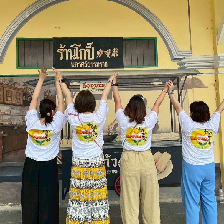 タイのお店の前で腕を上げるメンバー