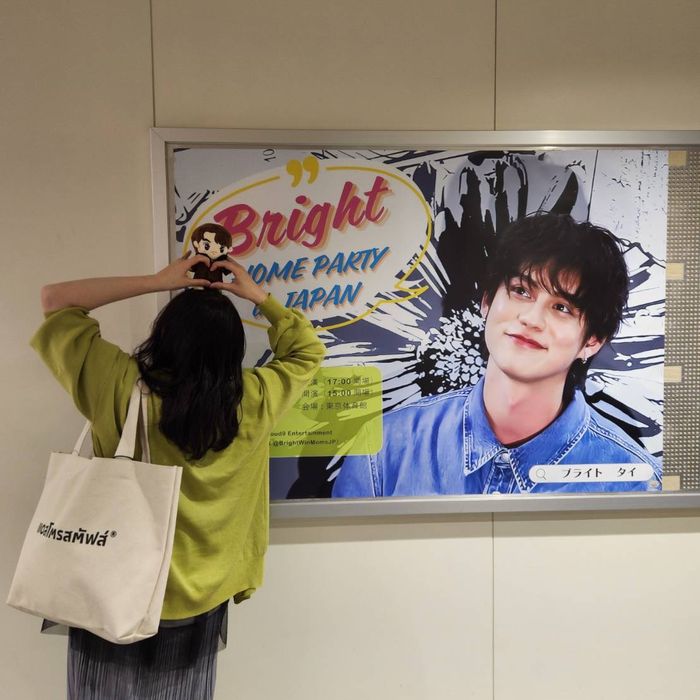 タイの街で大きなポスターの前に立つ参加者