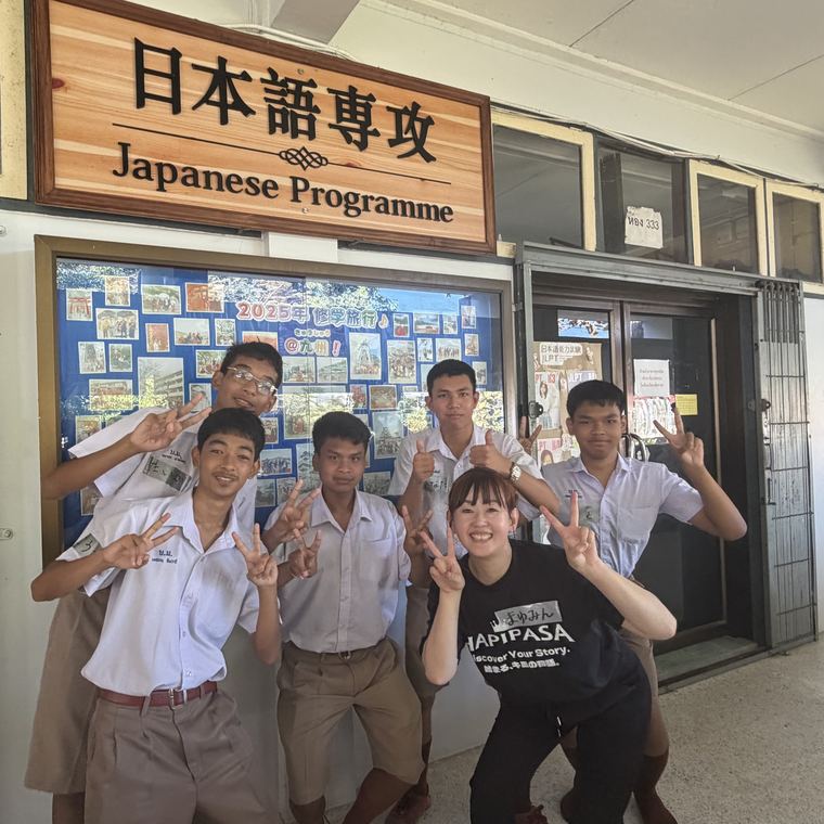 日本語専攻の看板の前でポーズをとる生徒たち